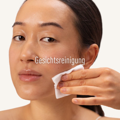 Frau wischt sich mit Wattetuch das Gesicht ab